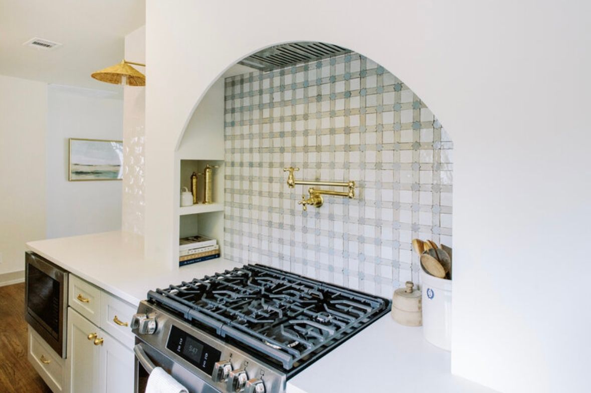 A kitchen with a stove top oven and a sink.