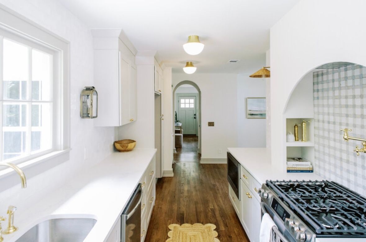 A kitchen with white cabinets and a stove top oven
