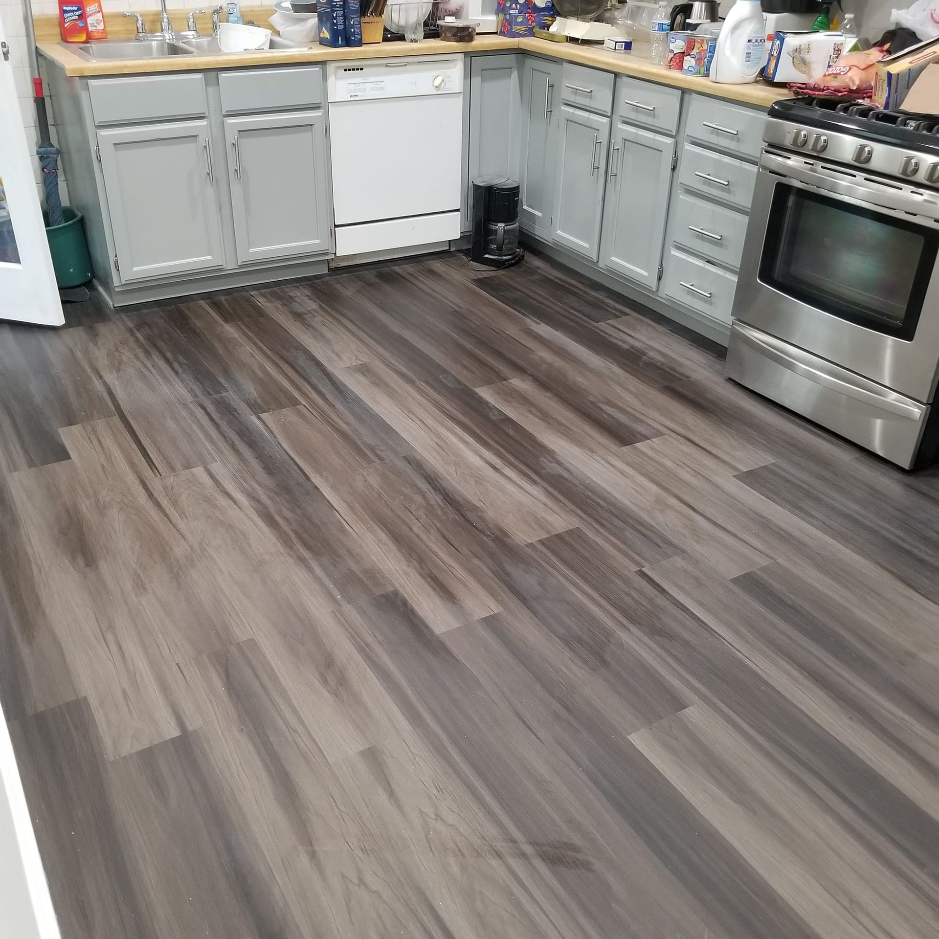 A kitchen with hardwood floors and stainless steel appliances
