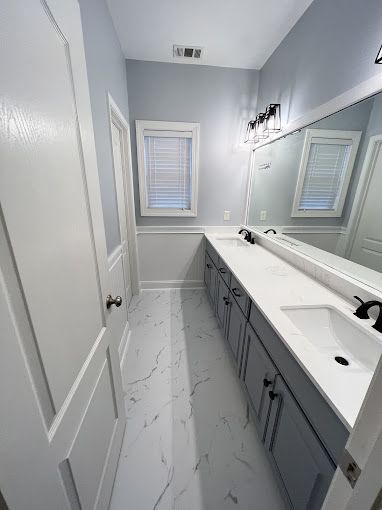 A bathroom with two sinks and a large mirror.