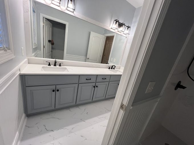 A bathroom with two sinks and a large mirror.