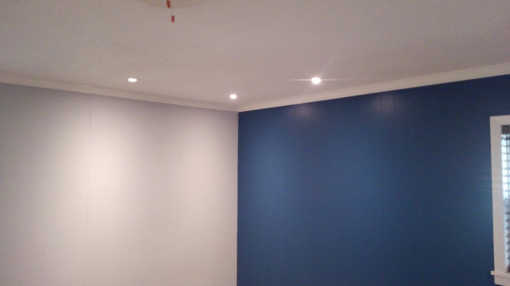 A room with blue walls and white walls and a window.