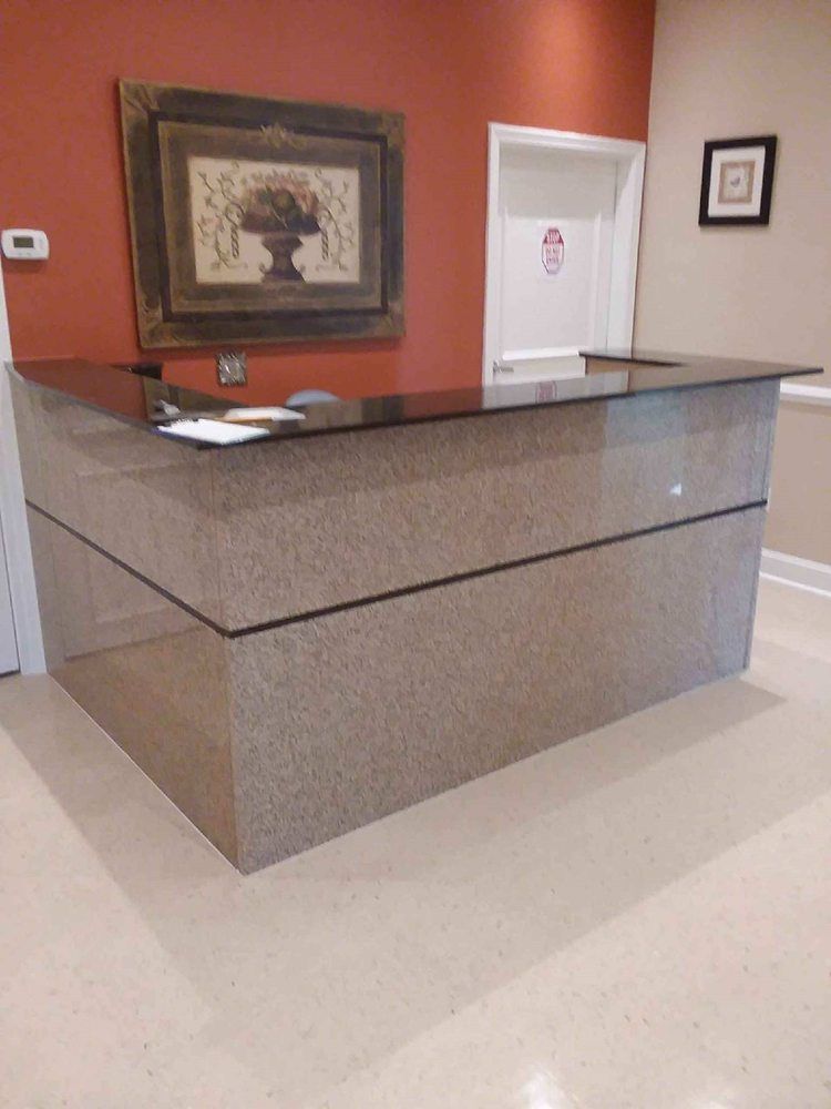 A large granite counter in a room with a picture on the wall above it.