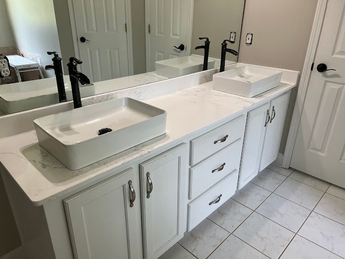 A bathroom with two sinks and a large mirror.