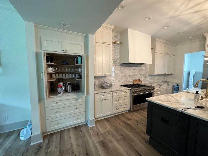 A kitchen with white cabinets and stainless steel appliances.