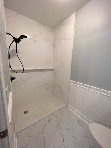 A bathroom with a walk in shower and a toilet.