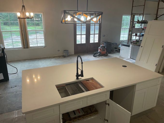 A kitchen with a sink , cabinets and a chandelier.