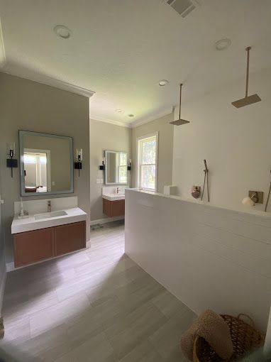 A bathroom with two sinks , a shower and a mirror.
