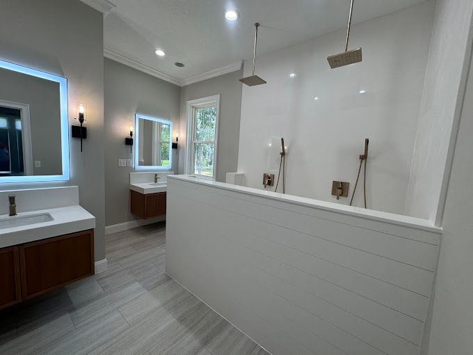 A bathroom with two sinks and a walk in shower.