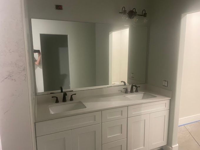A bathroom with two sinks and a large mirror.