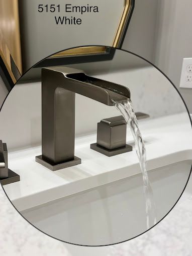 A bathroom sink with a waterfall faucet and a white counter top.