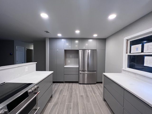 A kitchen with stainless steel appliances and gray cabinets