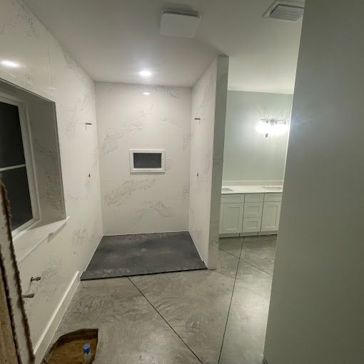 A bathroom with a walk in shower and a sink.