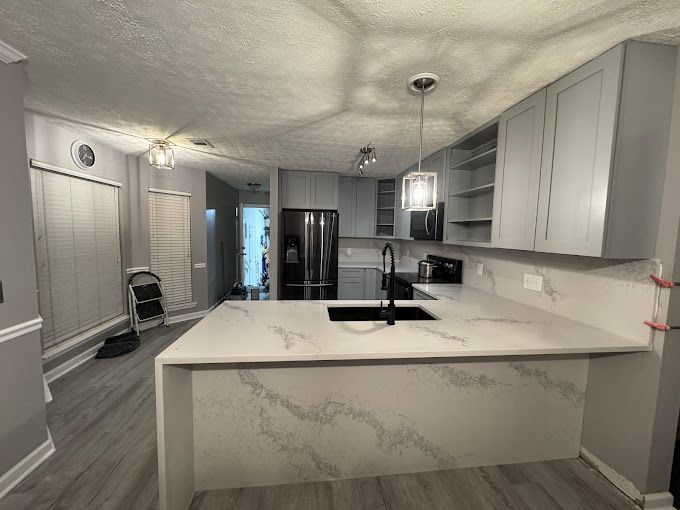 A kitchen with a large island and a sink.