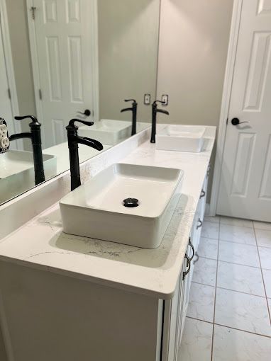 A bathroom with two sinks and a mirror.