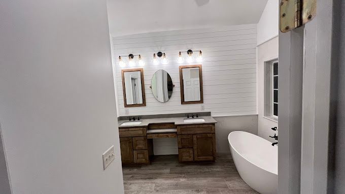 A bathroom with two sinks and a tub.