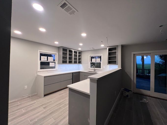 A kitchen with a lot of cabinets and sliding glass doors.