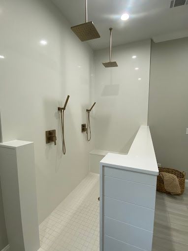 A bathroom with a walk in shower and two shower heads.