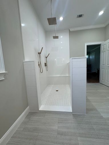 A bathroom with a walk in shower and a window.