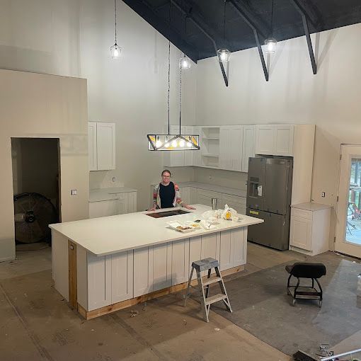 A man is standing at a large island in a kitchen.