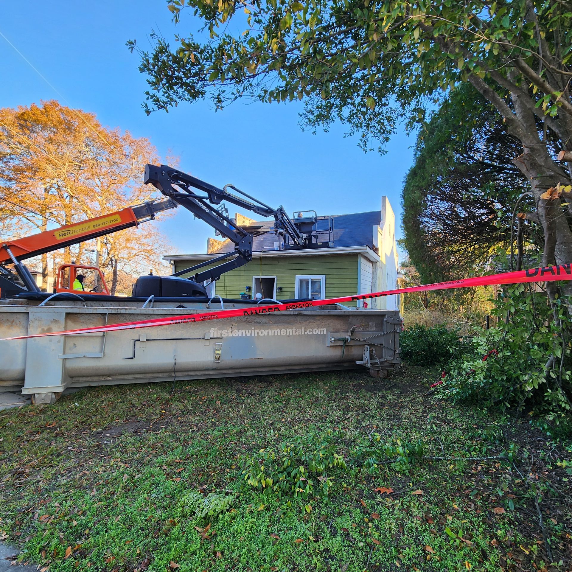 Crane next to a house, possibly for construction or repair work, with red tape around the property.
