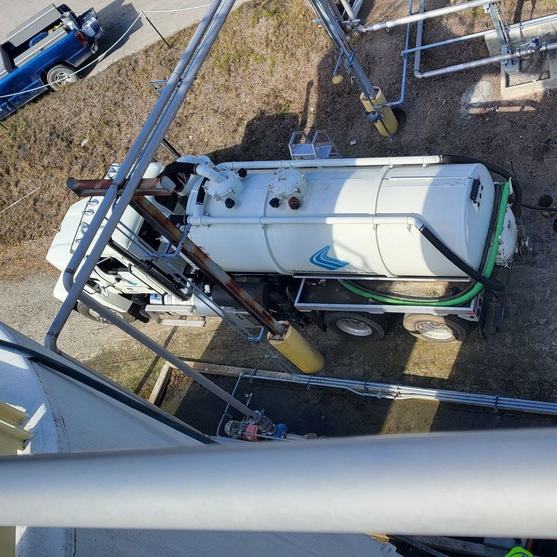 An aerial view of a vacuum truck parked on the side of the road.