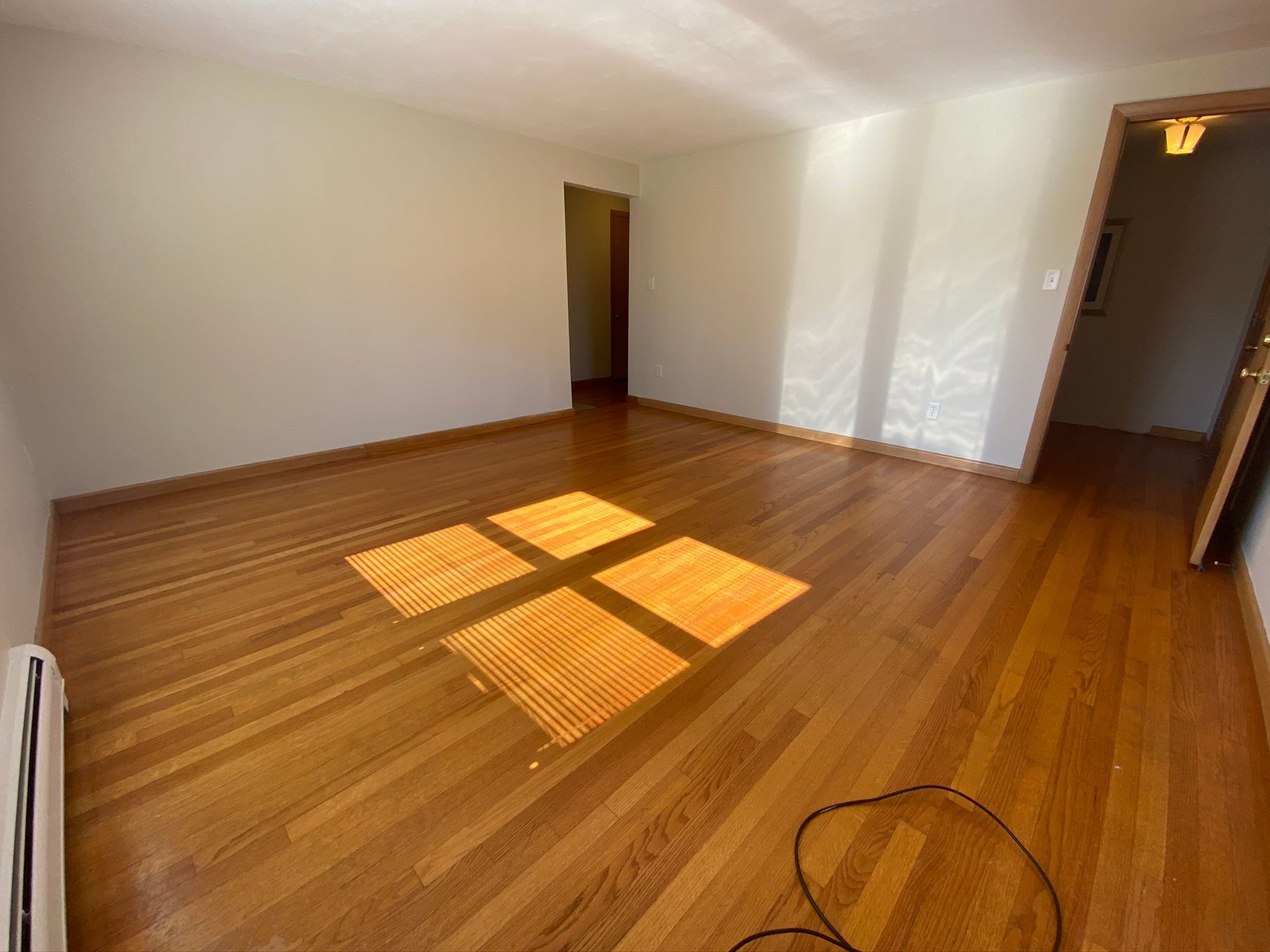 A living room with hardwood floors and white walls
