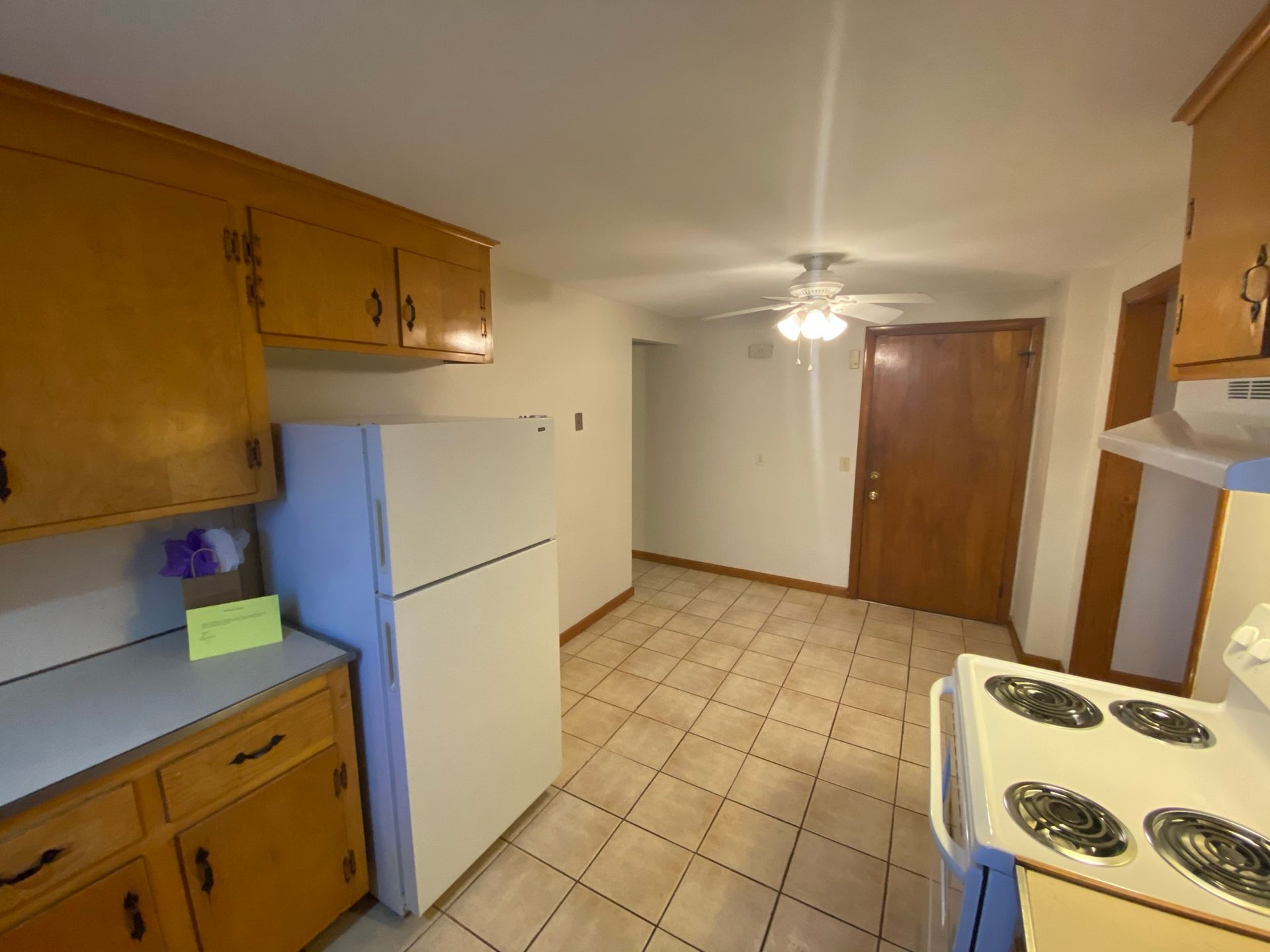 A kitchen with a stove , refrigerator , and cabinets