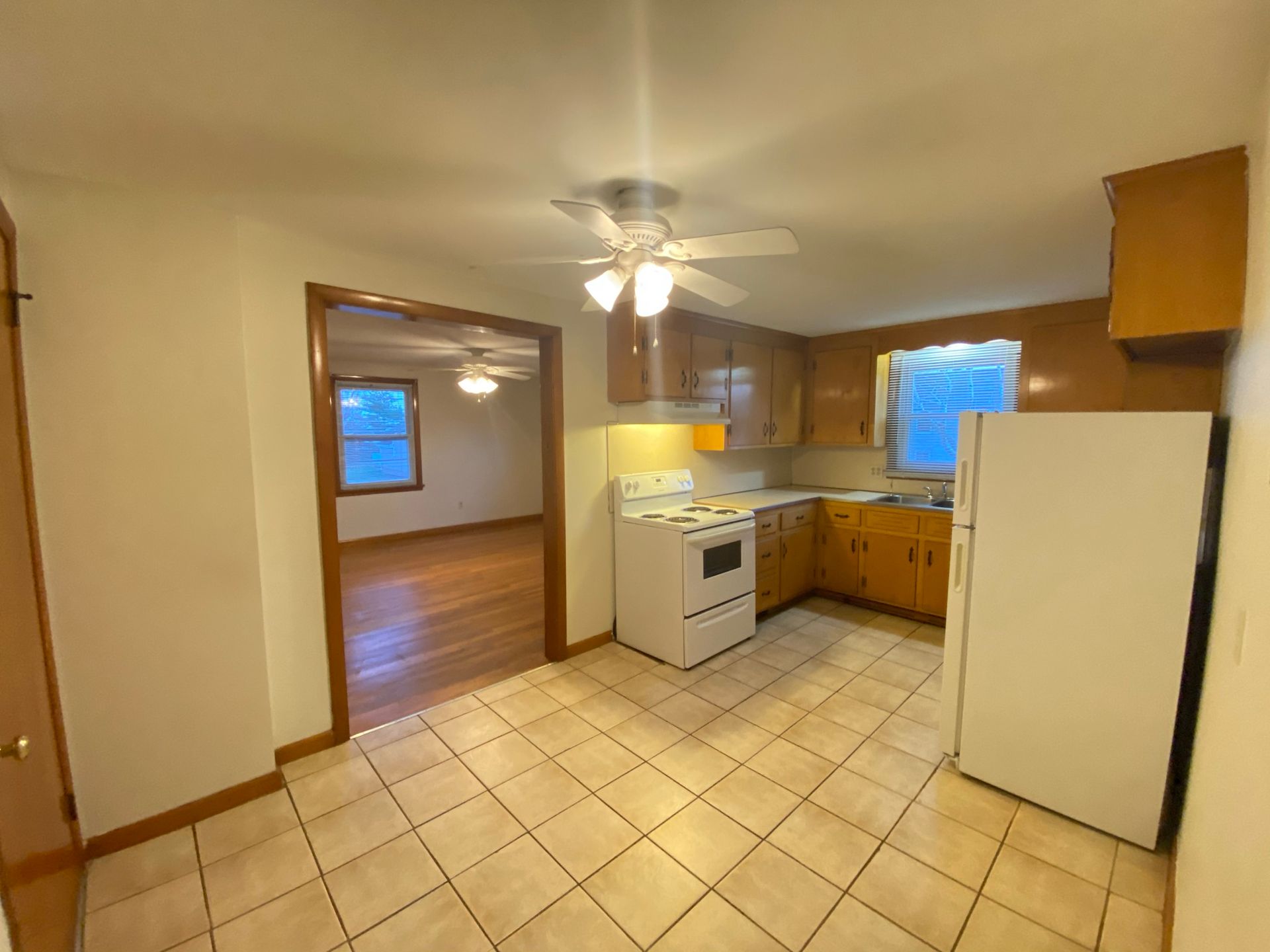 A kitchen with a stove , refrigerator , and ceiling fan.