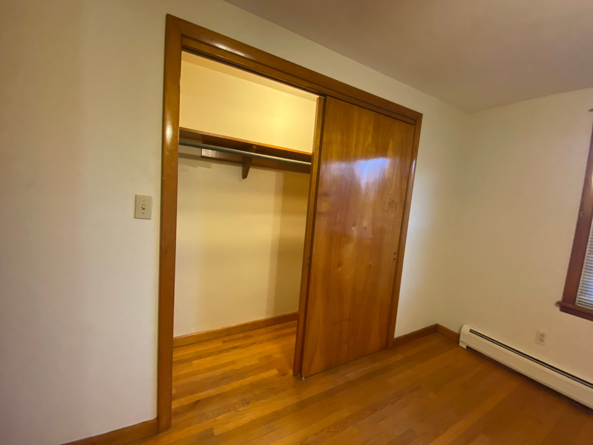 A bedroom with a walk in closet and a window