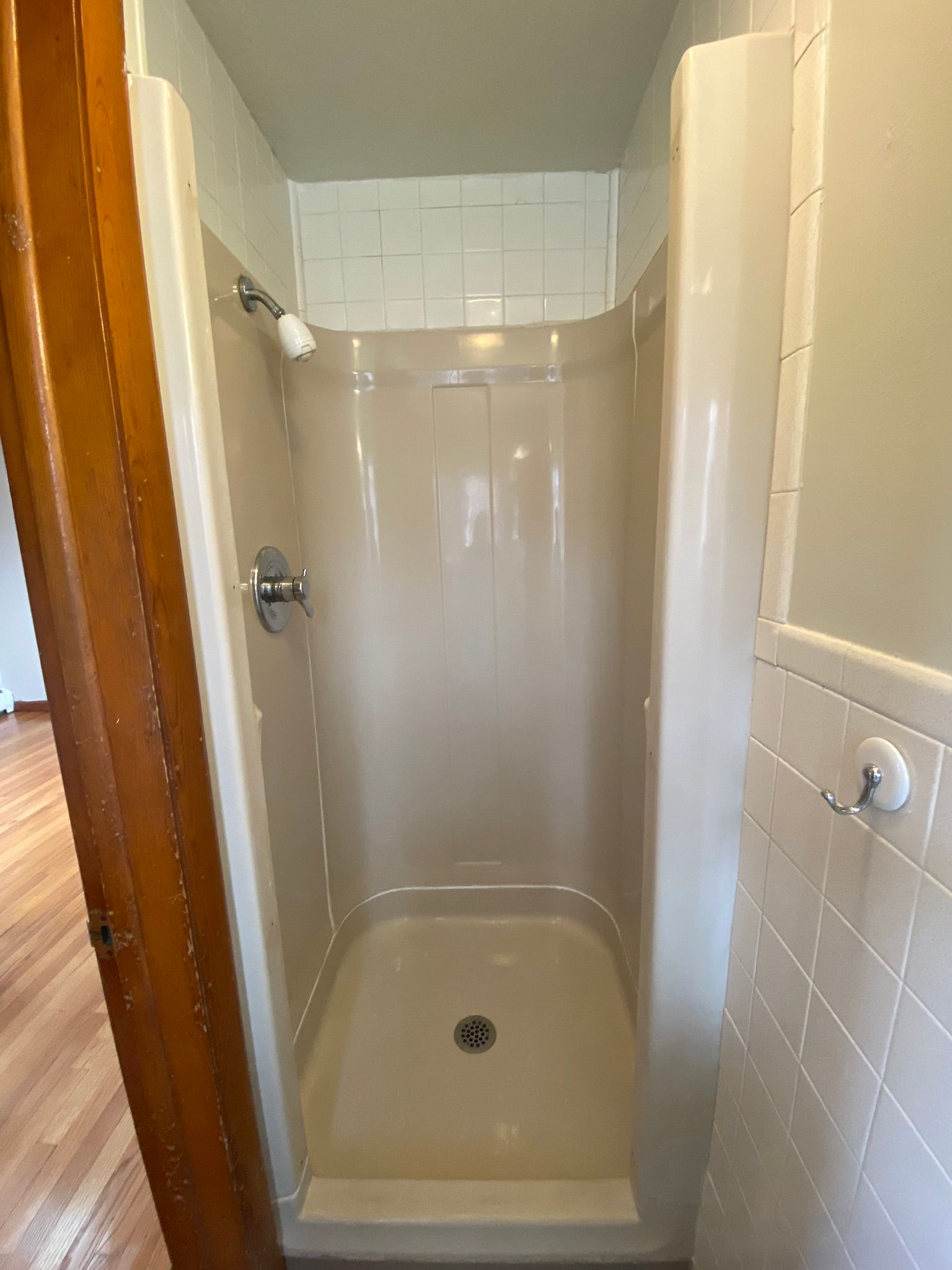 A bathroom with a shower stall and a door.