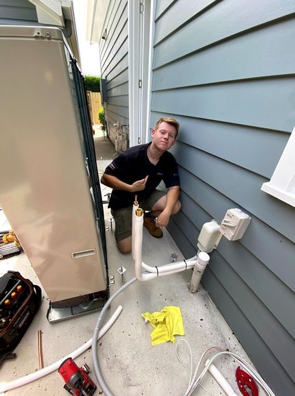 Men in a Black T-Shirt Installing New Aircon — Servicing Homes & Businesses in Albion Park, NSW