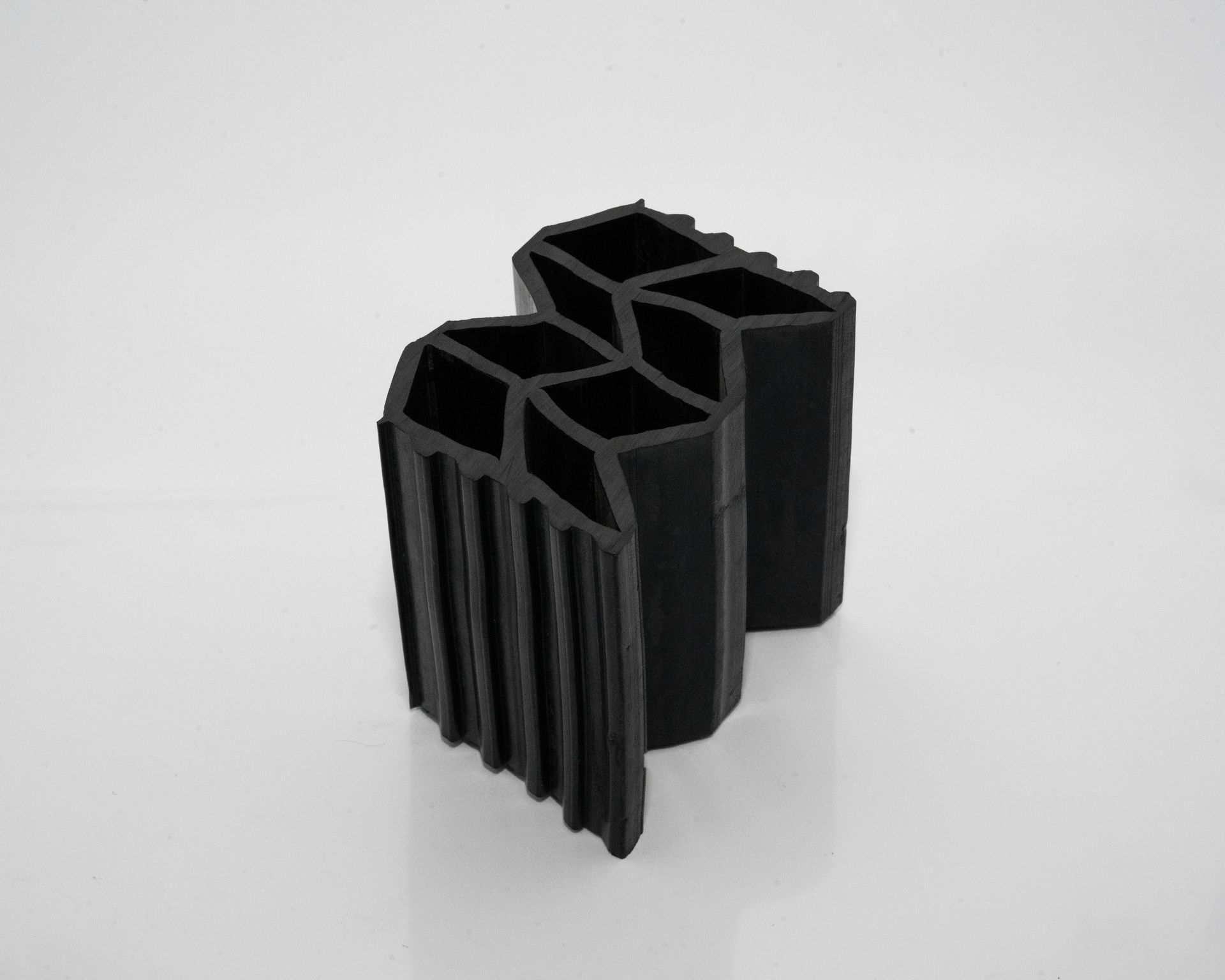 una pieza negra de hule está sentado sobre una superficie blanca.