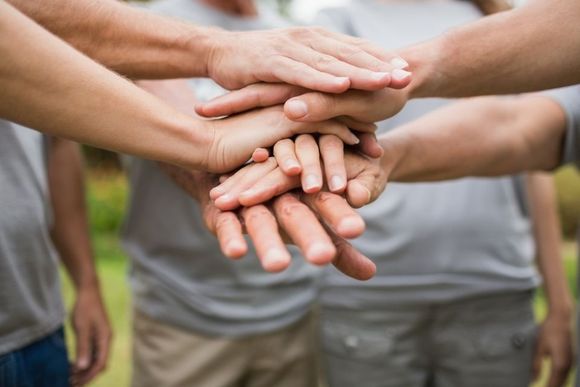 volunteer family putting their hands together