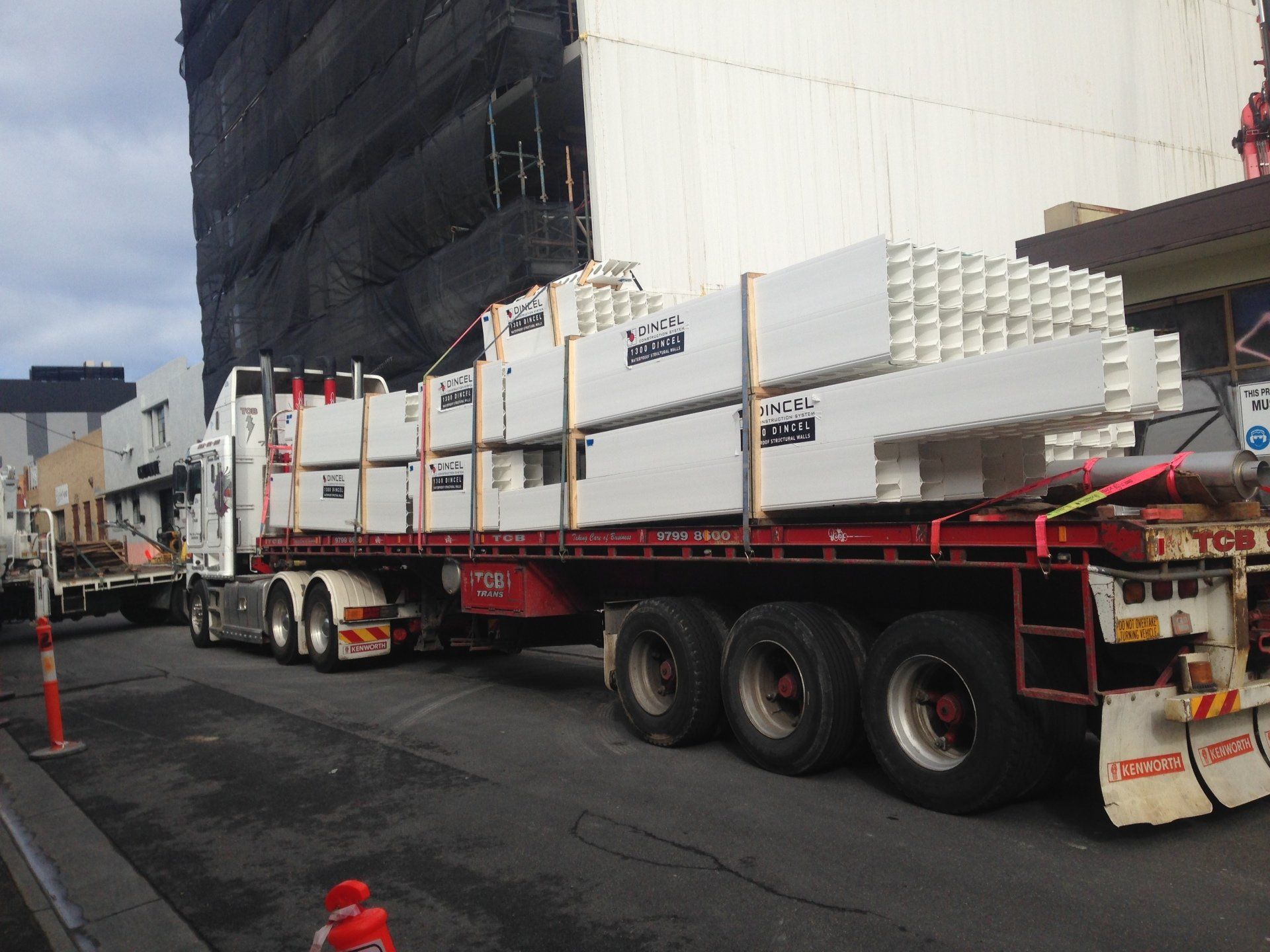 12 wheeler truck carrying white beams