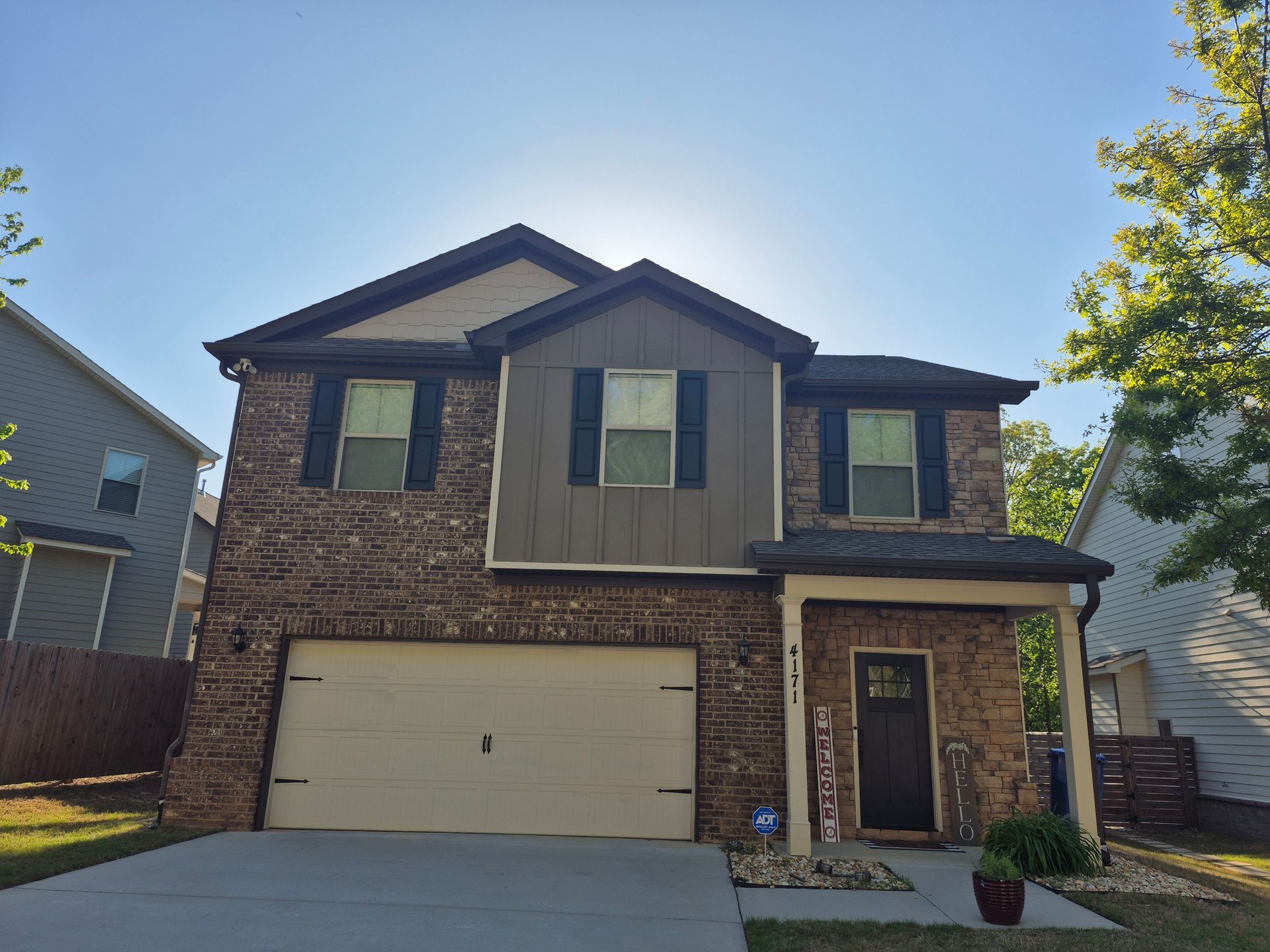 A living room with a couch , table , chair , vase and plants.
