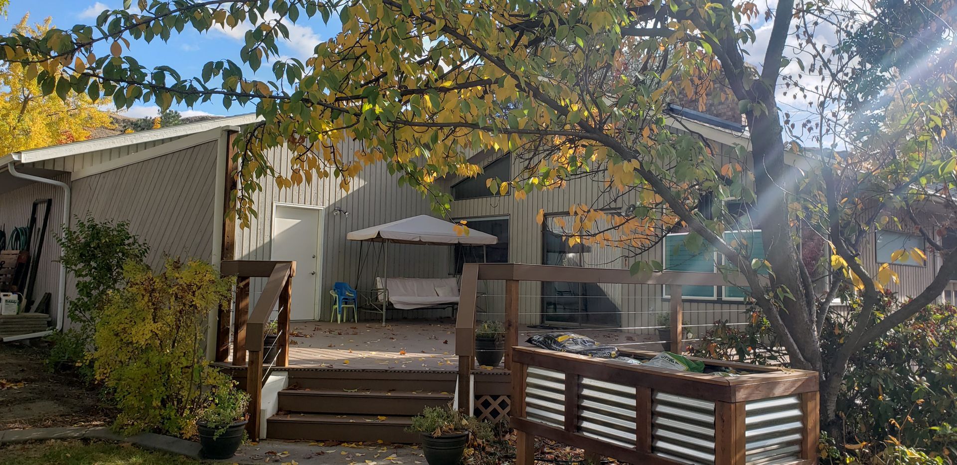 A home with a deck surrounded by trees and autumn leaves.