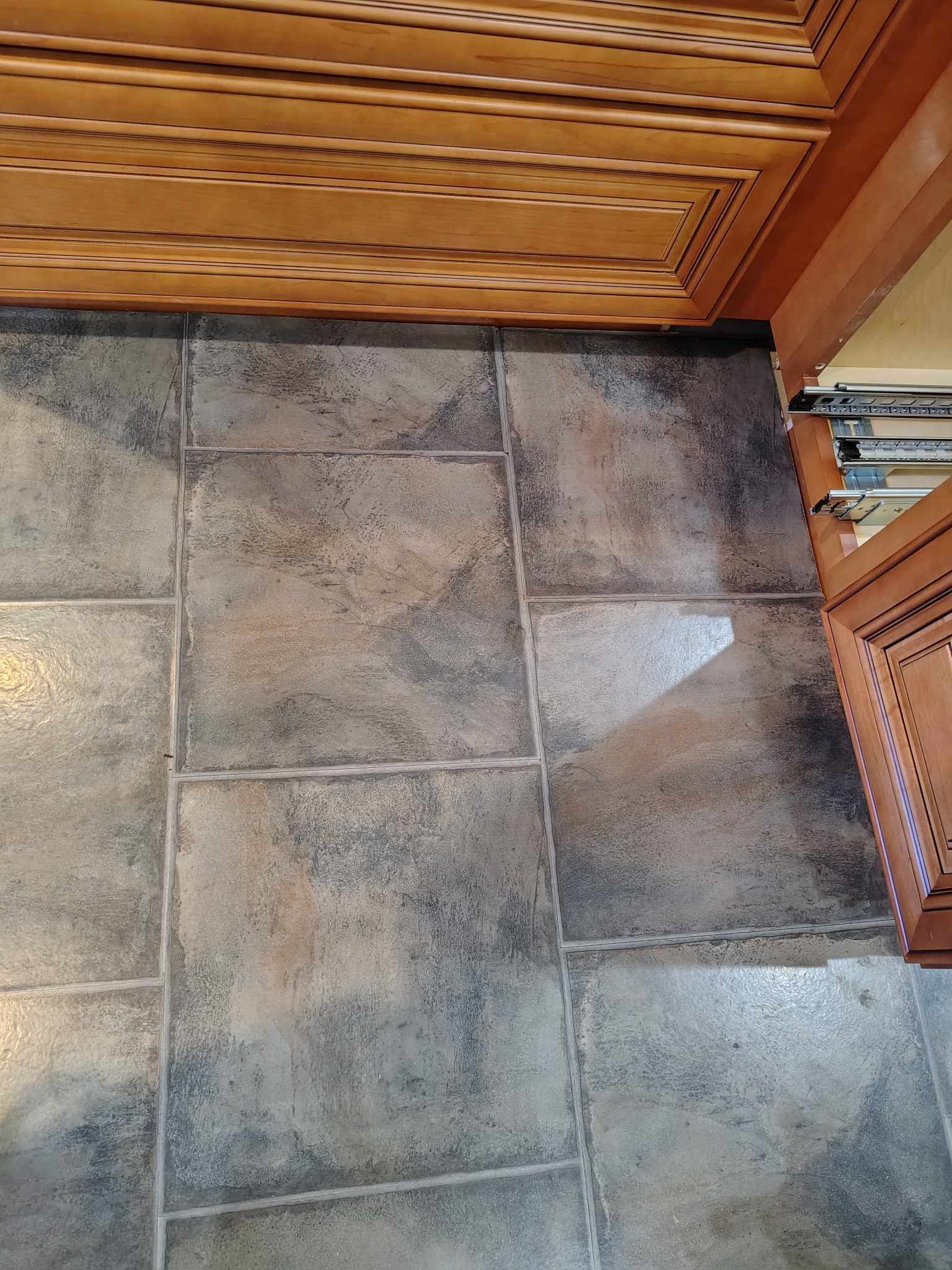 Brown tile floor beneath wooden cabinets.