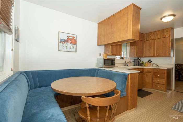 Bathroom with dark floor, textured walls, toilet, window, and wooden vanity.