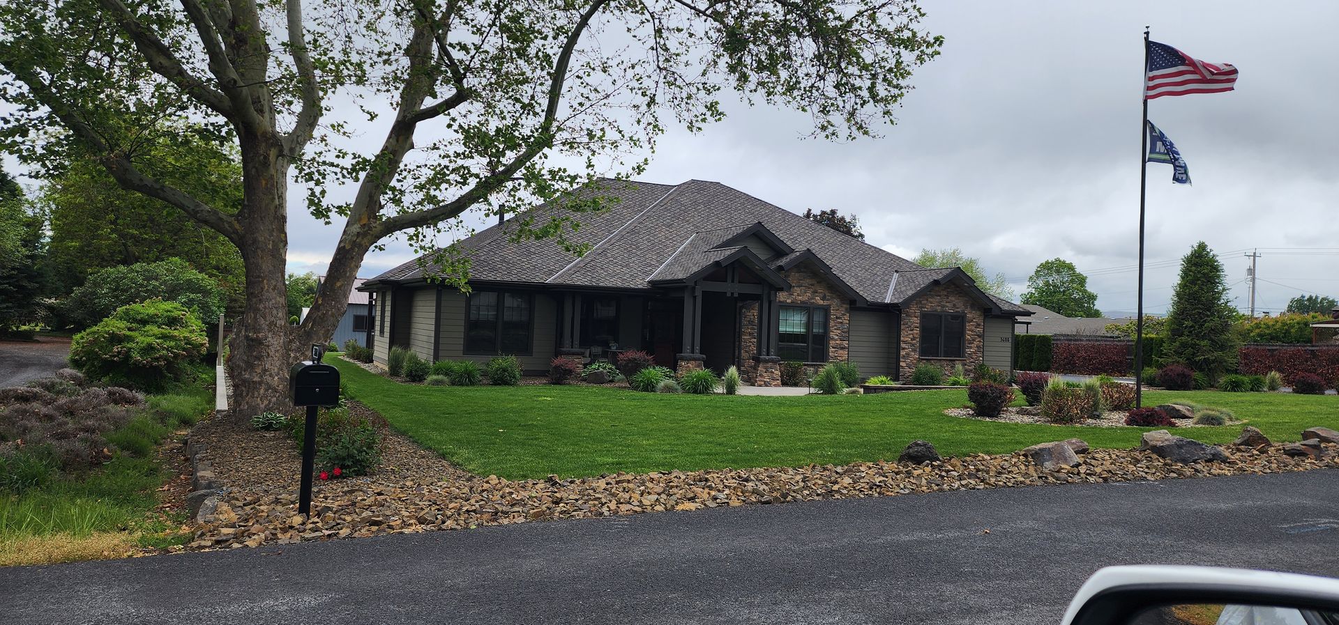 House with a stone facade and a flag pole with the American flag.