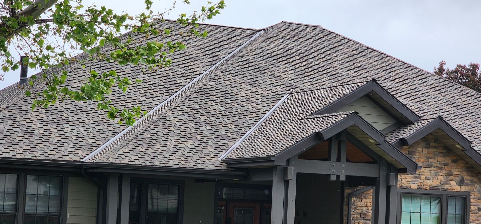 House with severely damaged wooden roof shingles.