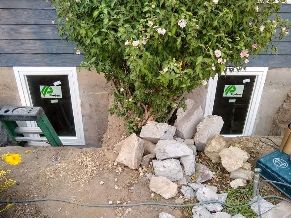 A ranch-style house with a red brick facade and a brown roof, seen on a cloudy day.