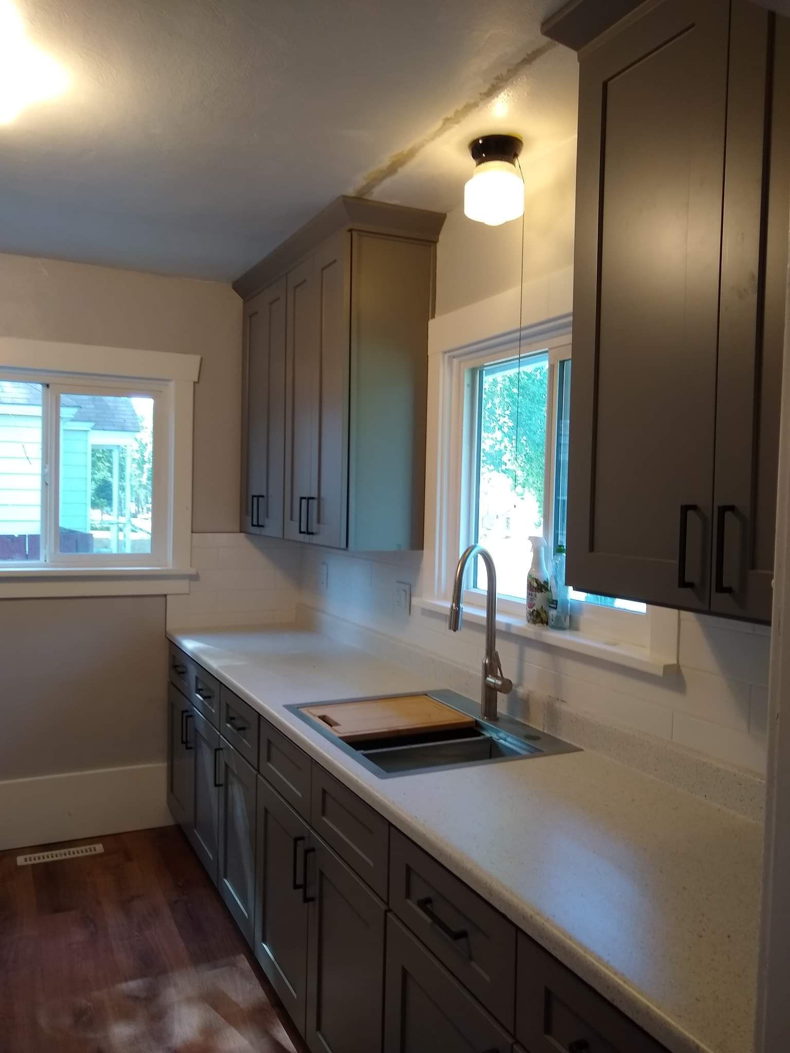 Bathroom with wood vanity, large mirror, window, and toilet. Gray and light wood tones.