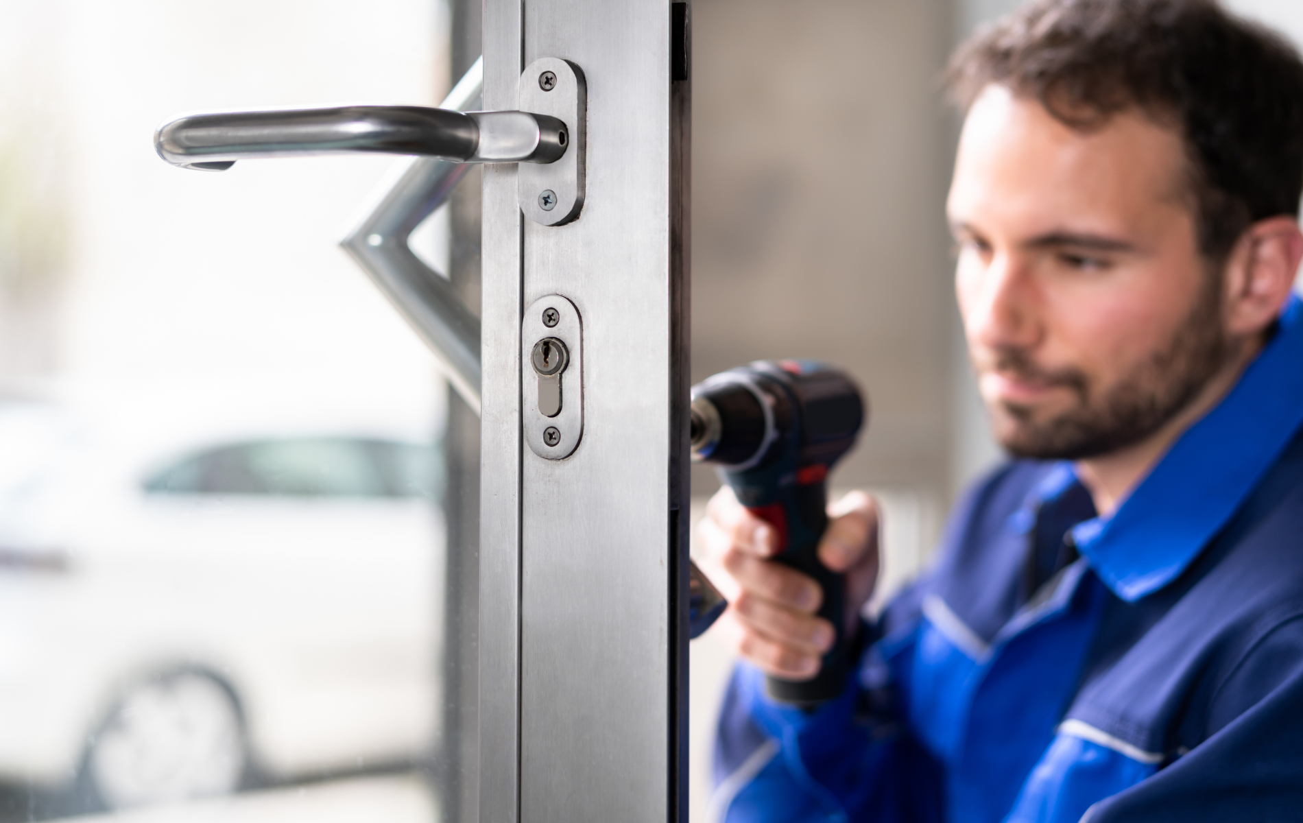 A man is fixing a door with a drill.
