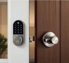 Silver smart lock keypad on a white door and doorknob on a brown door.