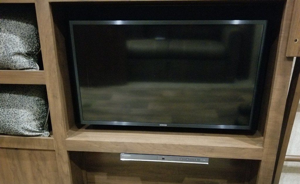 Una TV a schermo piatto è posizionata sopra un mobile porta TV in legno.