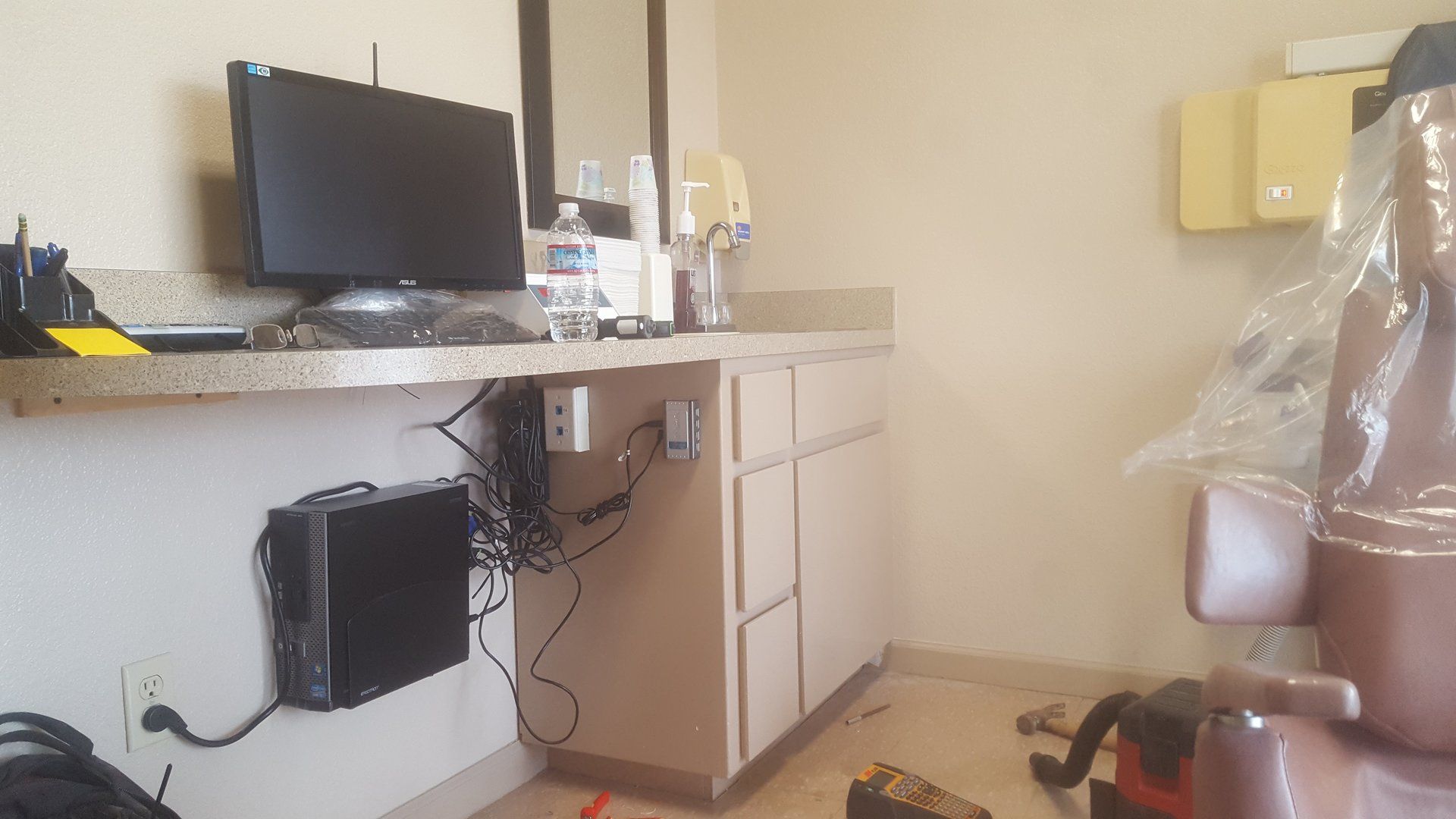 Uno studio dentistico con una poltrona odontoiatrica e un computer sul bancone.