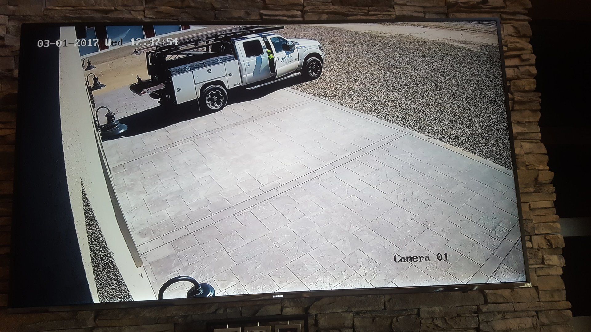 A tv screen shows a truck parked on the side of the road