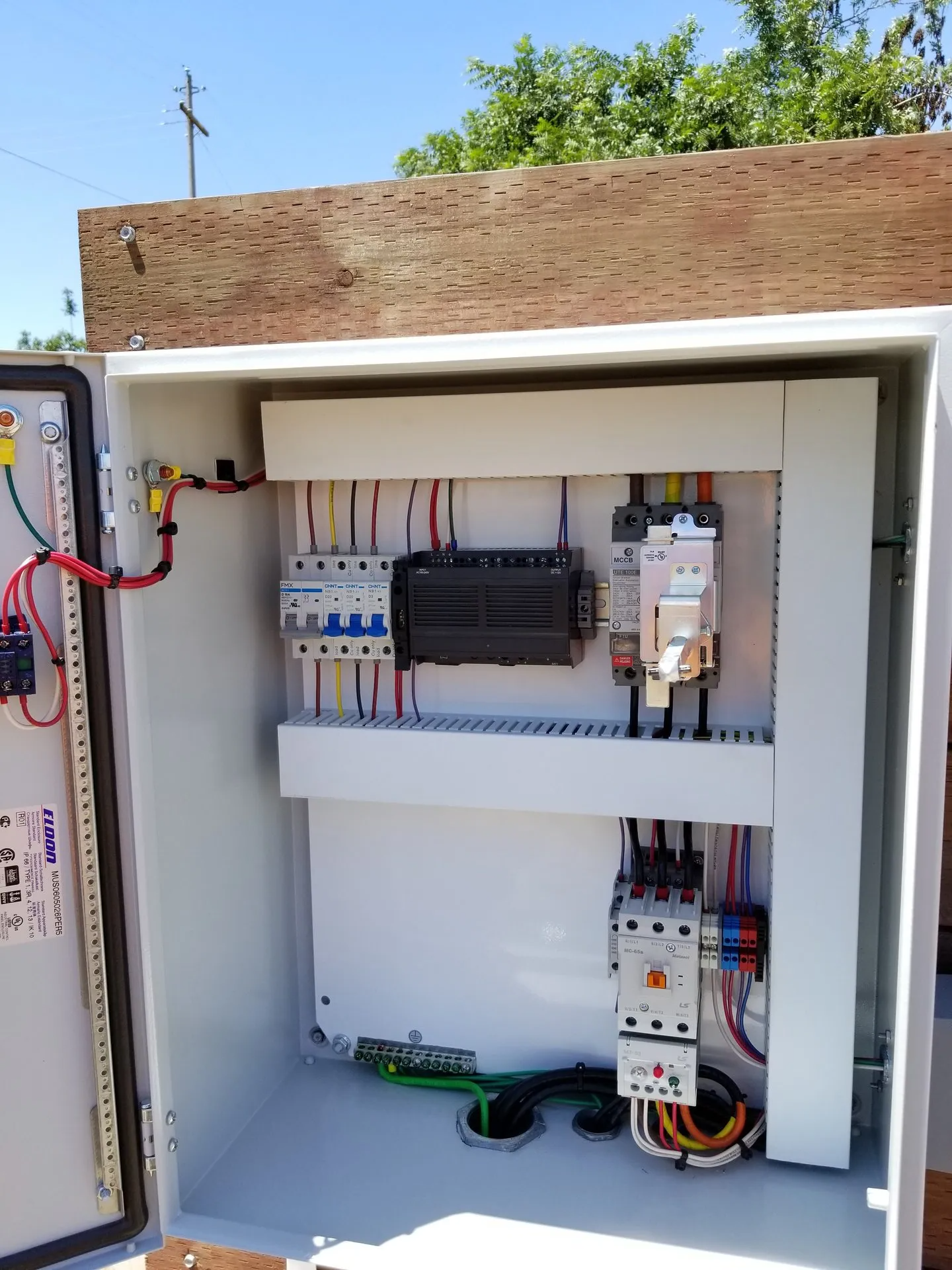 A white box with a lot of wires inside of it