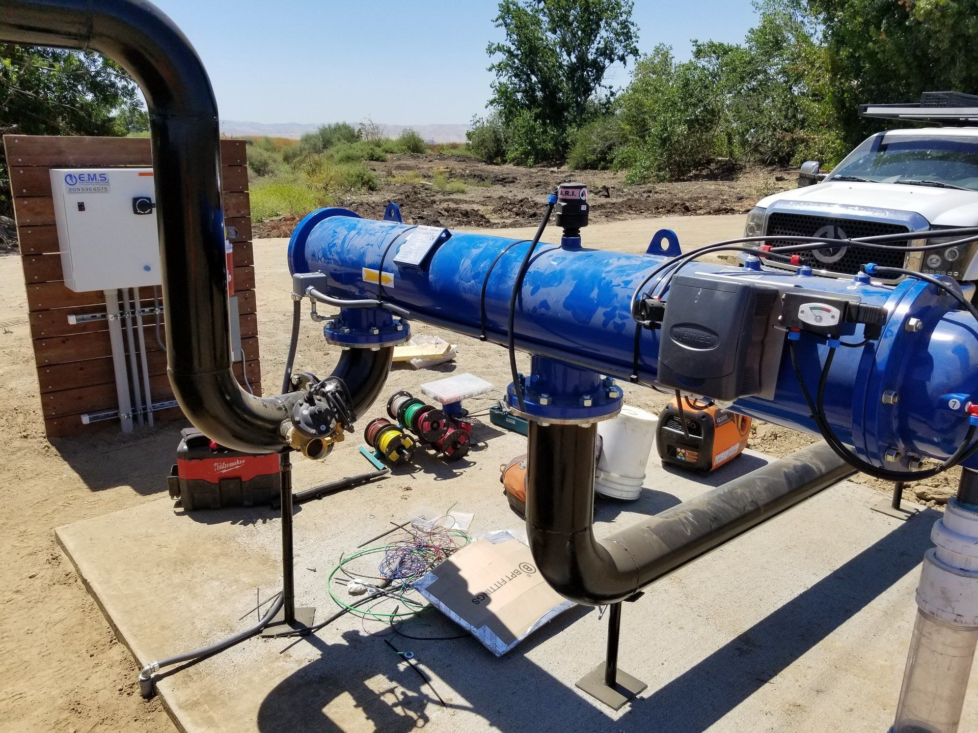 A large blue pipe is sitting on the ground next to a truck.